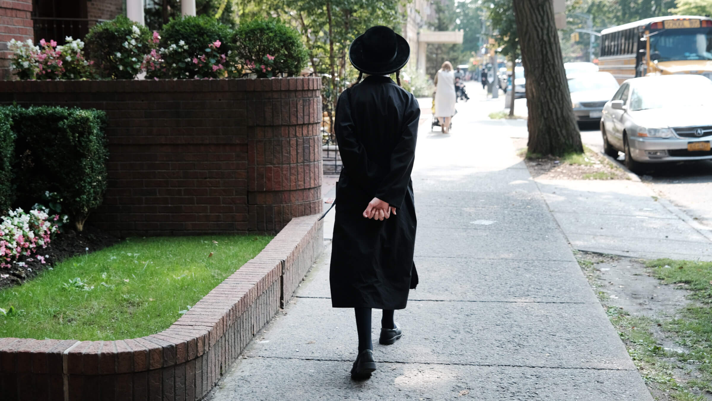 An orthodox Jewish boy walks down a street outside of a yeshiva school in Borough Park on September 12, 2022.