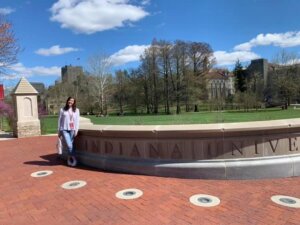Naomi Yankellow standing in front of an entrance sign at Indiana University