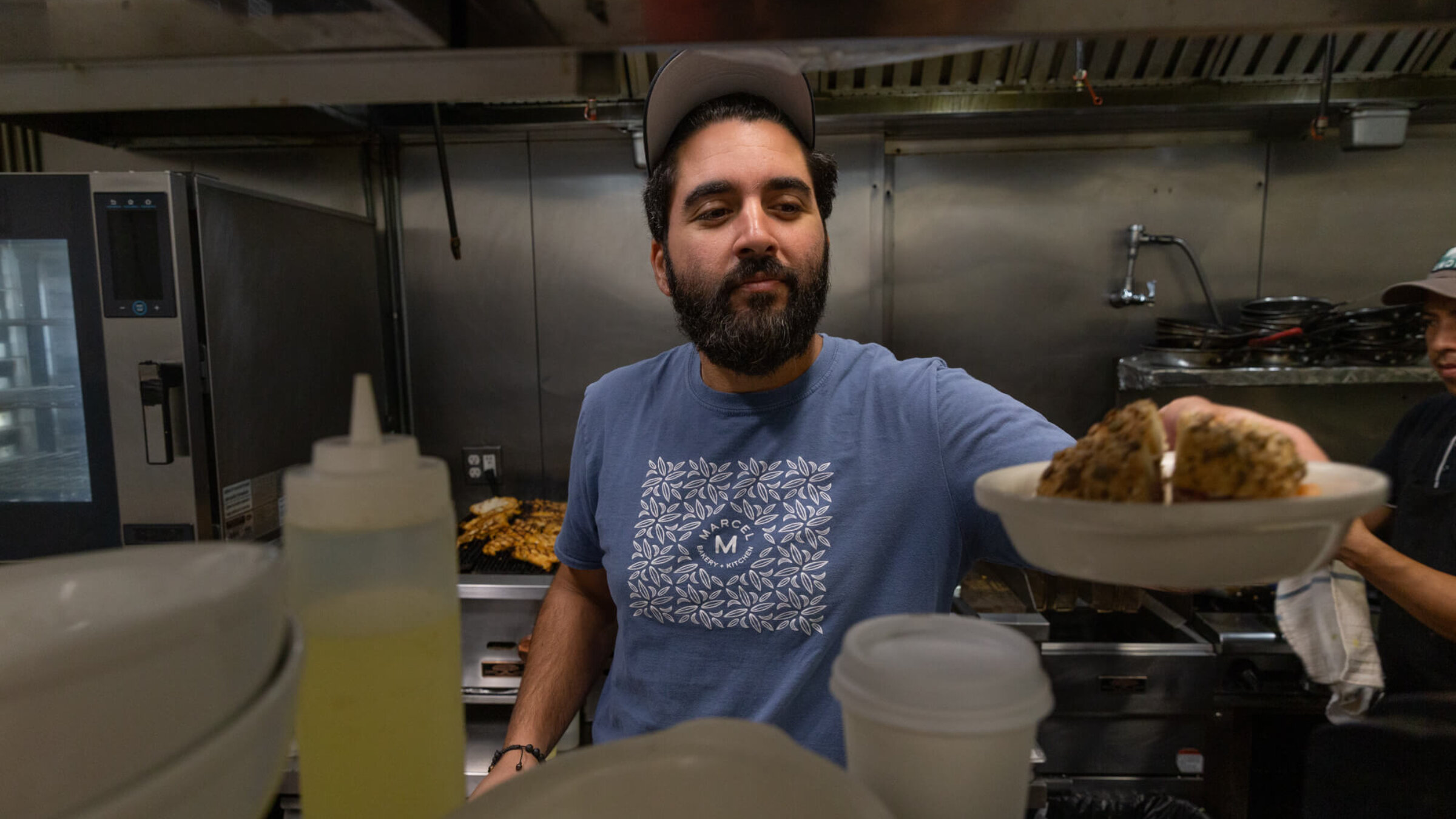 Meny Vaknin, chef and owner of the Israeli cafe Marcel, serves up his signature bagel sandwich: "The Committed Jew." 