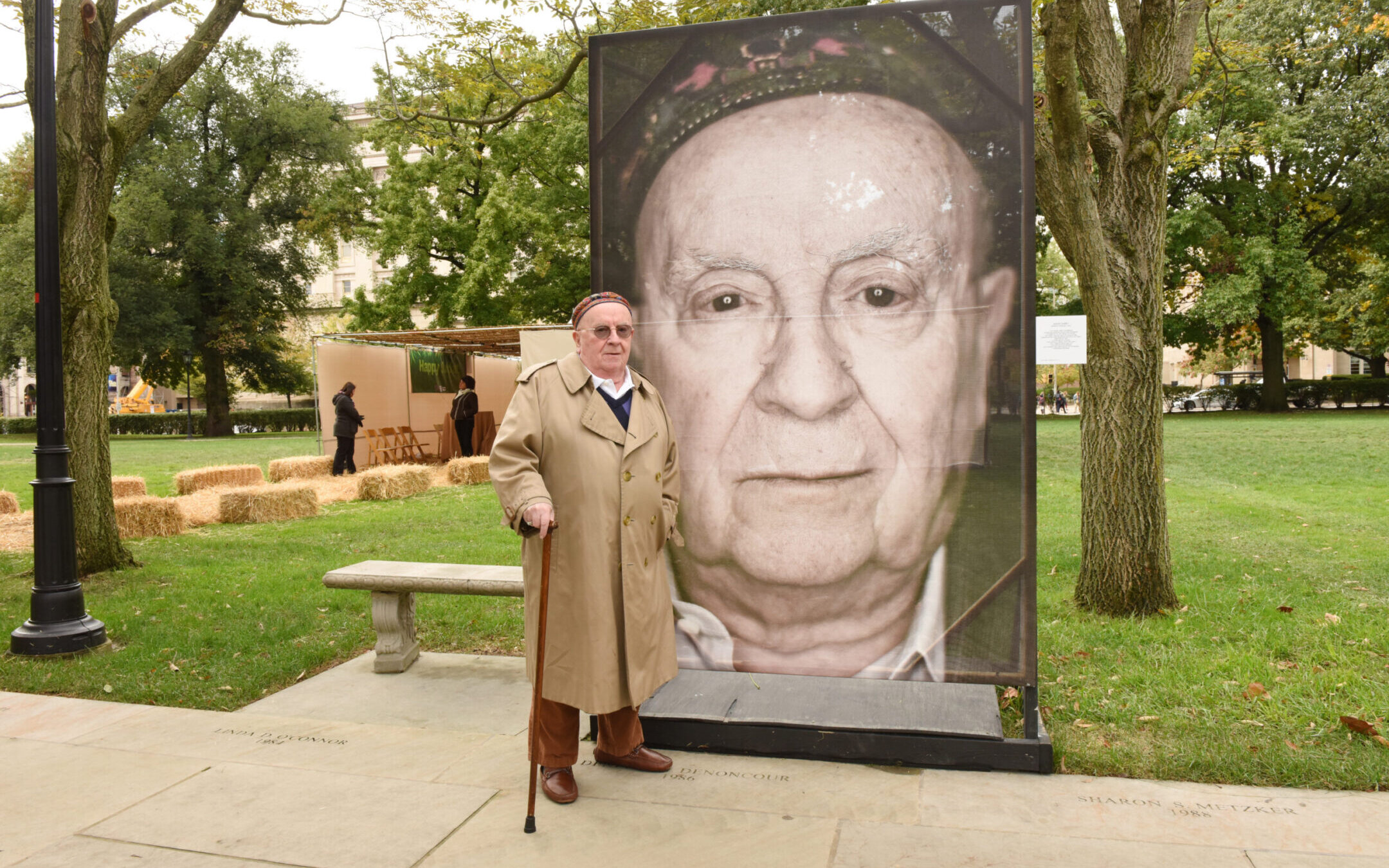 Judah Samet stands next to his portrait, part of Luigi Toscano’s “Lest We Forget” project at the University of Pittsburgh in 2019. (Photo by Hector Corante, courtesy of Holocaust Center of Pittsburgh)