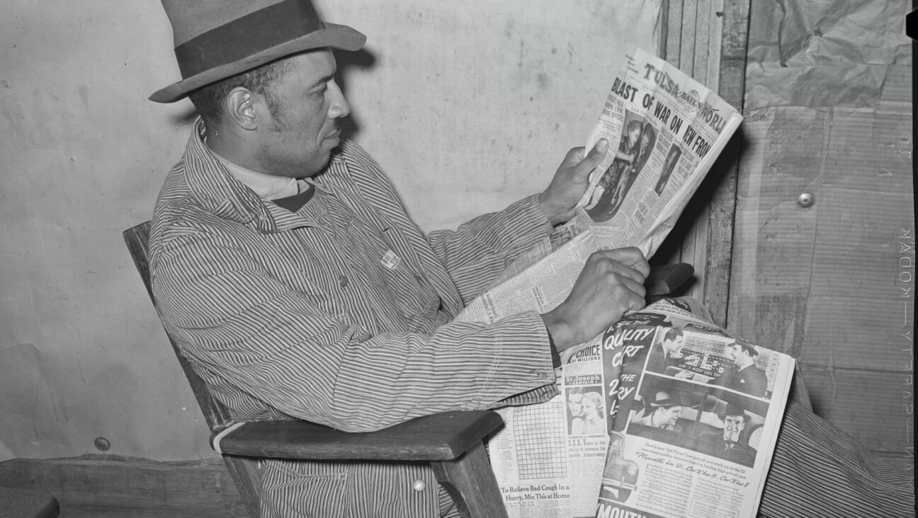 An Oklahoma farmer reads a newspaper.