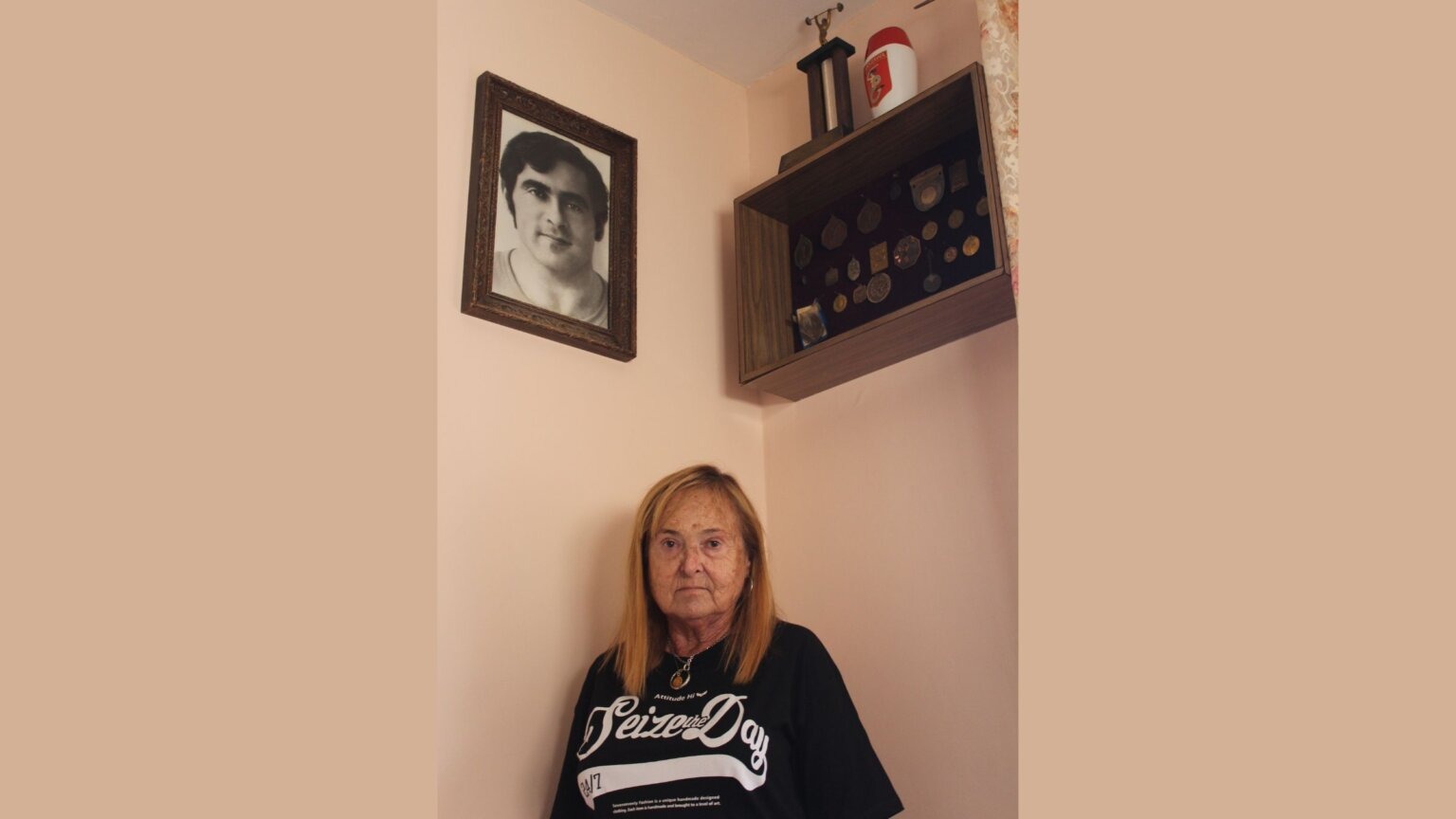 Nina Fridman in her apartment in Israel with weightlifting trophies earned by her brother Zev. (Hillel Kuttler)