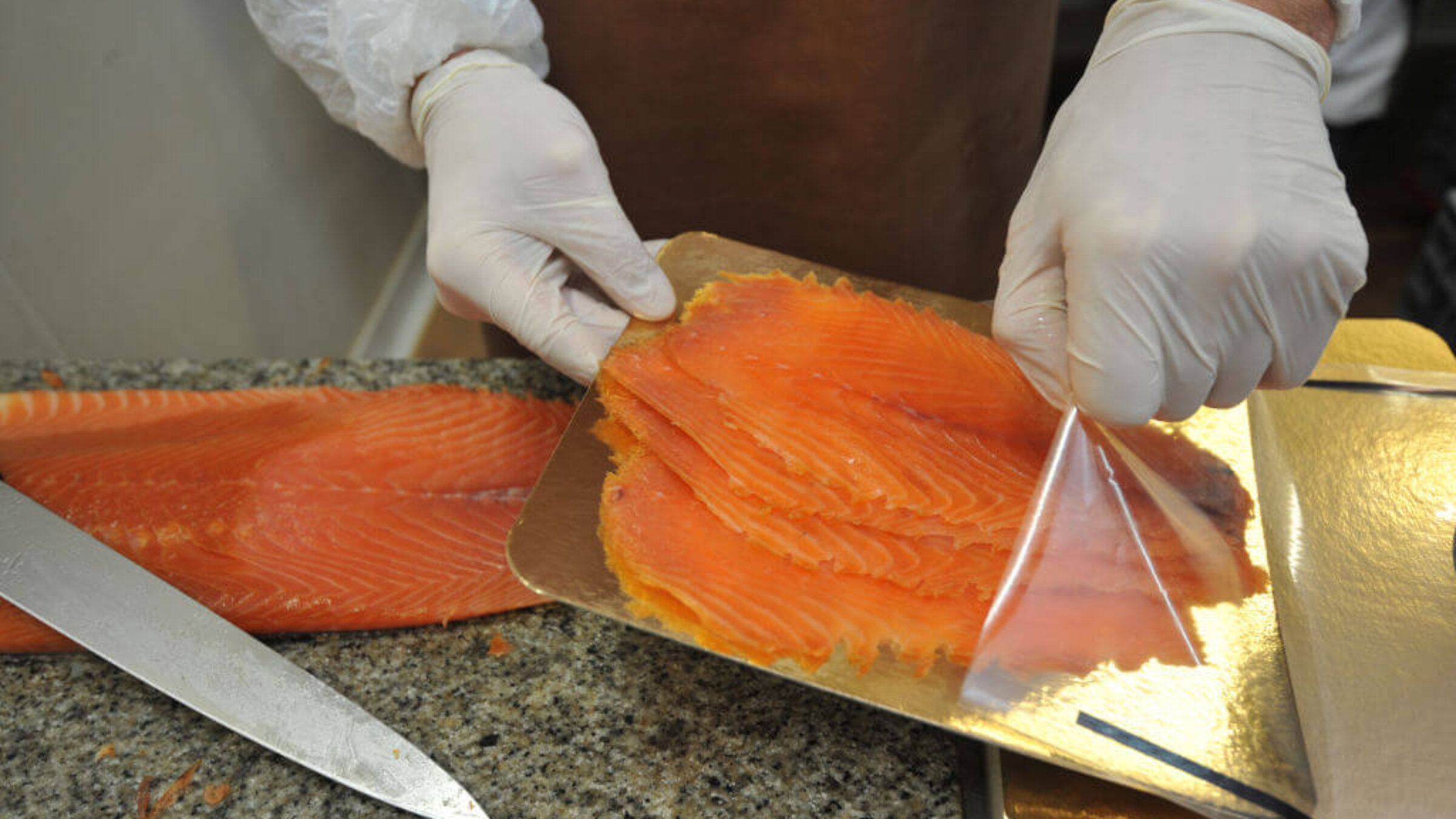 A worker packages slices of salmon in a hand smoked salmon factory in Quiberon in western France on November 23, 2011.