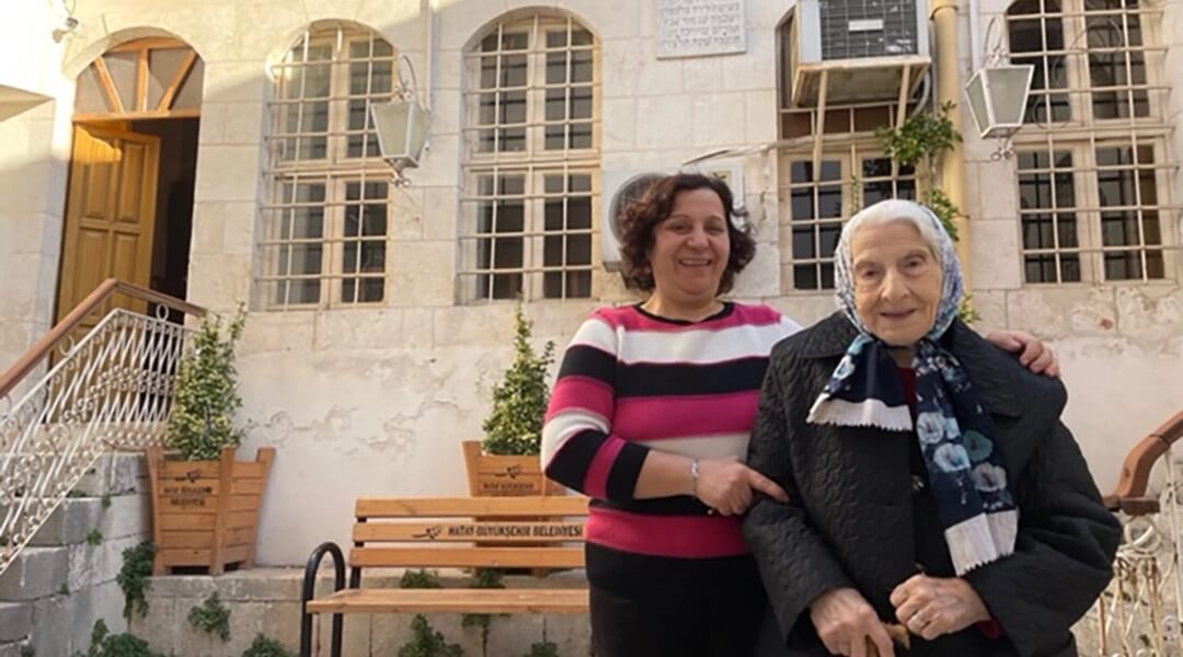 Olga stands with her husband’s 90-year-old mother, Adile, in Antakya.