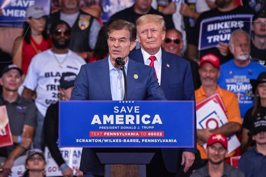 Mehmet Oz, who is running for the U.S. Senate, speaks as former President Donald Trump stands behind him during a campaign rally in support of Oz and Doug Mastriano for governor of Pennsylvania on Sept. 3, 2022. 
