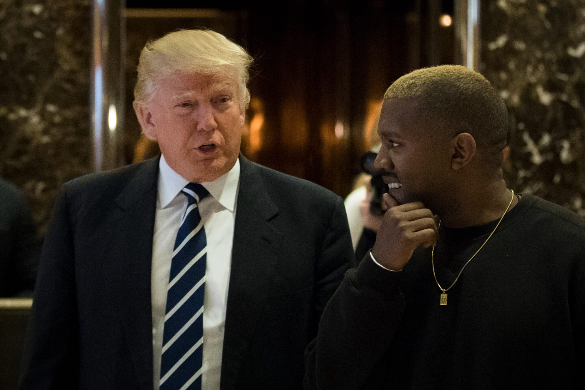 Then President-elect Donald Trump, left, and Kanye West walk into the lobby at Trump Tower, Dec. 13, 2016, in New York City. 