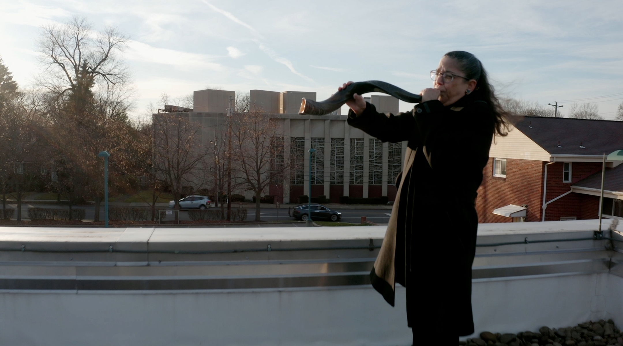 Audrey Glickman, a survivor of the 2018 Tree of Life synagogue shooting in Pittsburgh, blows the shofar outside the building in the new HBO documentary “A Tree of Life.” (HBO)