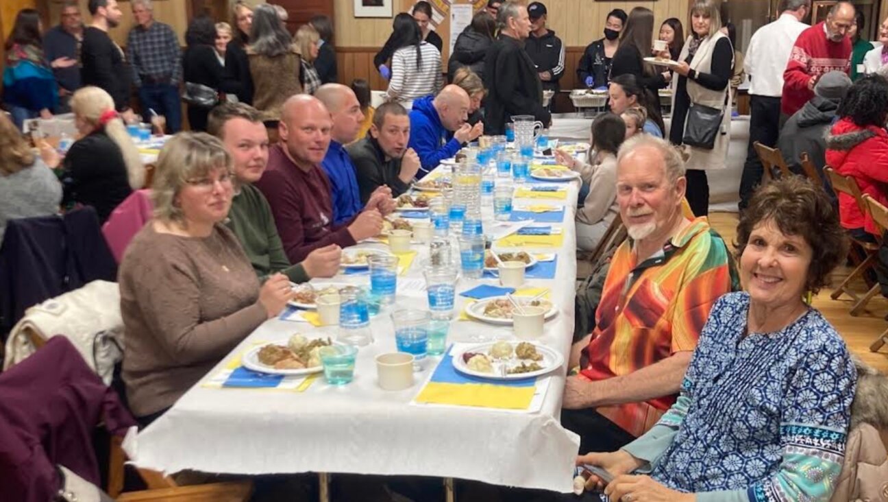 Ukrainian evacuees celebrate a pre-Thanksgiving meal at the Ukrainian American Civic Center in Buffalo, New York. (Courtesy of Jewish Federations of North America)