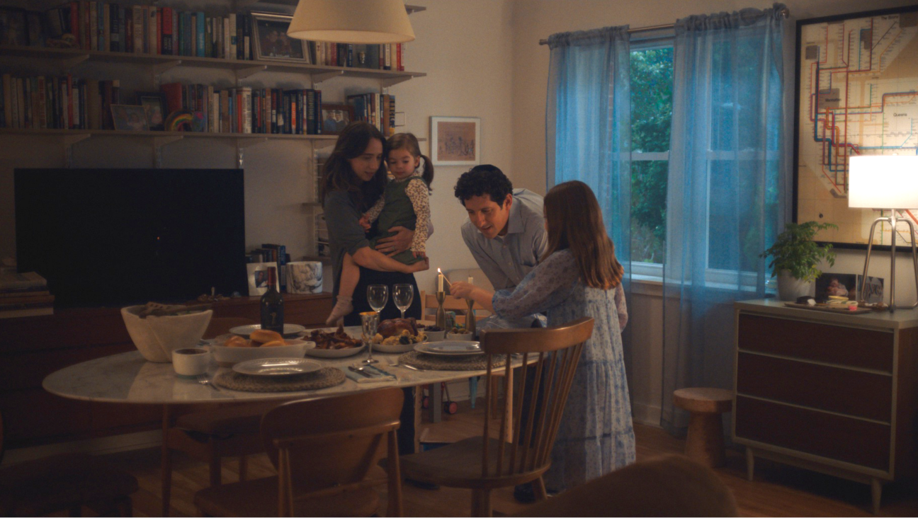 Jodi Kantor, as portrayed by Zoe Kazan, and her family lighting Shabbat candles in "She Said." 