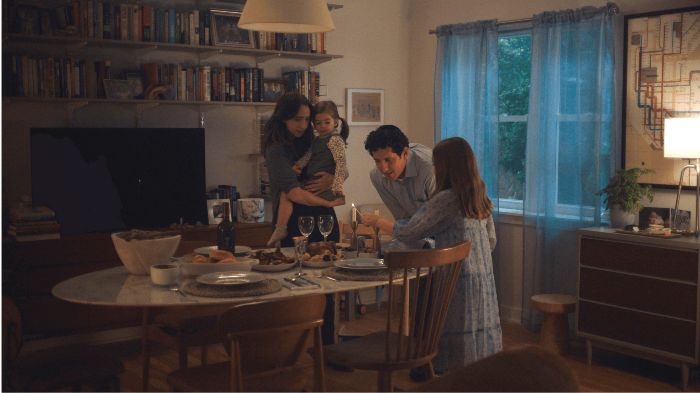 Jodi Kantor, as portrayed by Zoe Kazan, and her family lighting Shabbat candles in "She Said." 