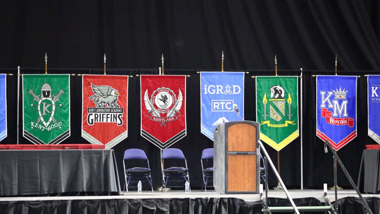 Banners featuring schools from the Kent School District are displayed on stage during a graduation ceremony last spring. An official with the district said this week that school libraries might be required to offer books disputing the Holocaust.