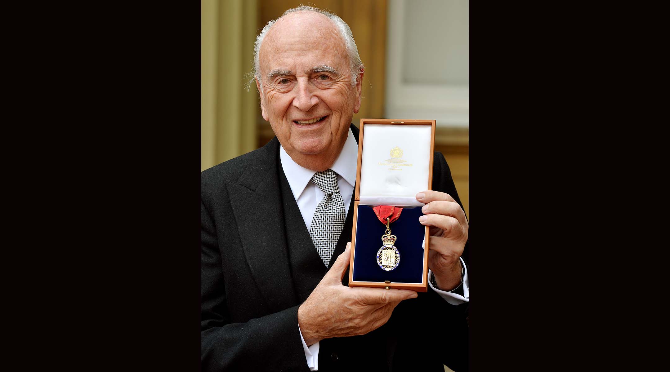 Lord David Young holds his insignia of member of the Order of the Companions of Honour after it was presented to him by the Prince of Wales in London, May 15, 2015. (John Stillwell/WPA Pool/Getty Images)