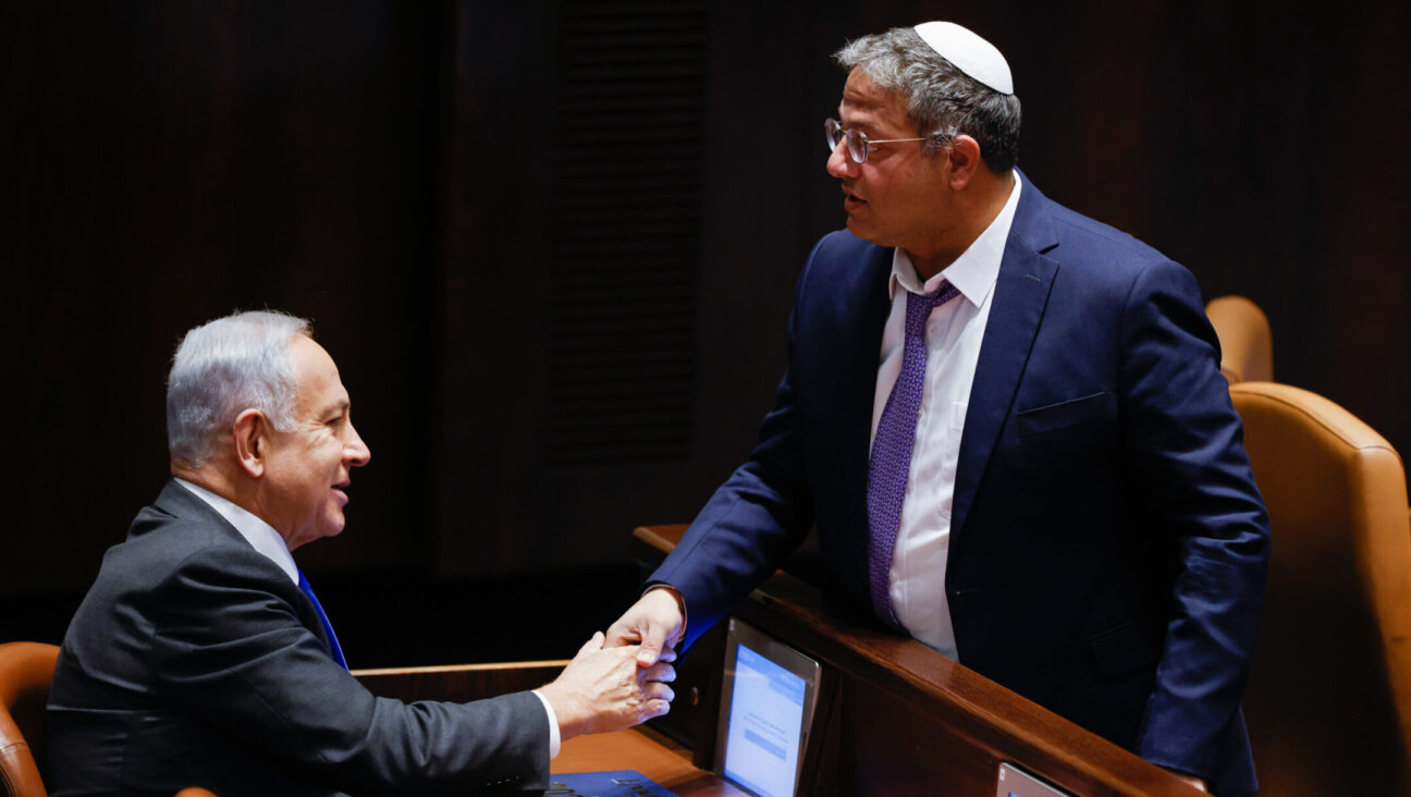 Benjamin Netanyahu, left, shakes the hand of Otzma Yehudit party leader Itamar Ben-Gvir in the Knesset in Jerusalem, December 28, 2022.