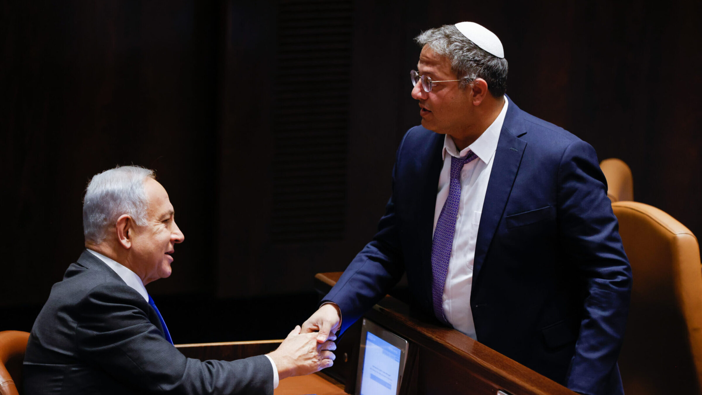 Benjamin Netanyahu, left, shakes the hand of Otzma Yehudit party leader Itamar Ben-Gvir in the Knesset in Jerusalem, December 28, 2022.