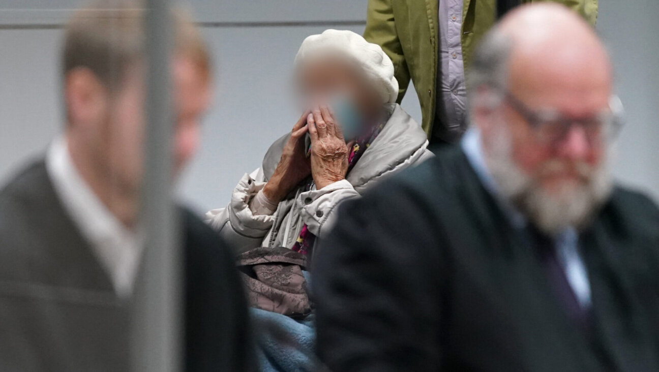 Irmgard Furchner, a former secretary for the SS commander of the Stutthof concentration camp, arrives with her lawyers during her trial in Itzehoe, Germany, Dec. 6, 2022. German courts require the face of defendants to be obscured in photographs. (Marcus Brandt/Pool/AFP via Getty Images)