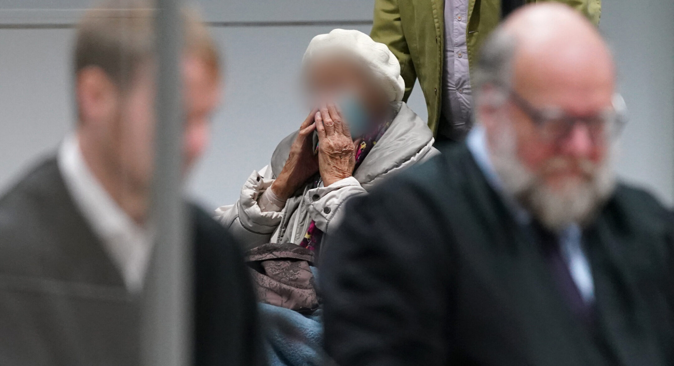 Irmgard Furchner, a former secretary for the SS commander of the Stutthof concentration camp, arrives with her lawyers during her trial in Itzehoe, Germany, Dec. 6, 2022. German courts require the face of defendants to be obscured in photographs. (Marcus Brandt/Pool/AFP via Getty Images)