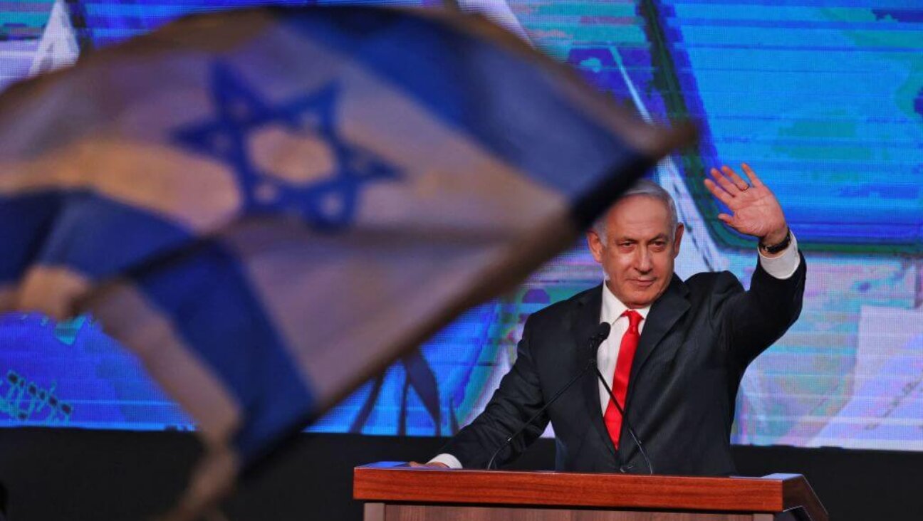 Israeli Prime Minister Benjamin Netanyahu, leader of the Likud party, waves to supporters at the party campaign headquarters in Jerusalem early on March 24, 2021.