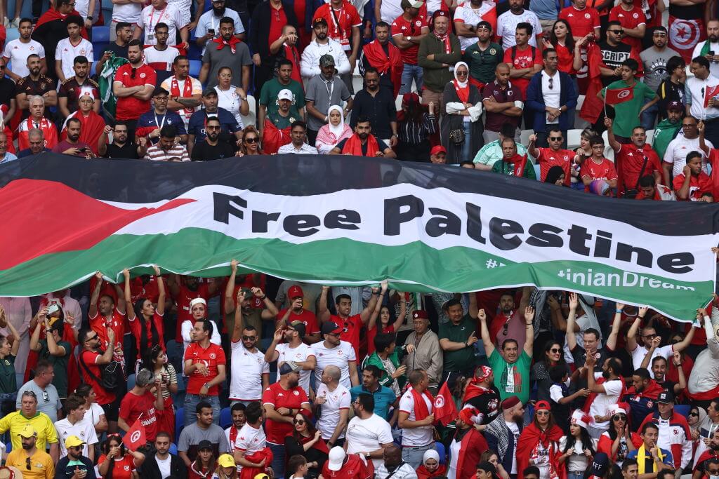 Fans hold a Palestinian flag with "Free Palestine" written on it during the FIFA World Cup match between Tunisia and Australia at Al Janoub Stadium on Nov. 26, 2022 in Al Wakrah, Qatar. 