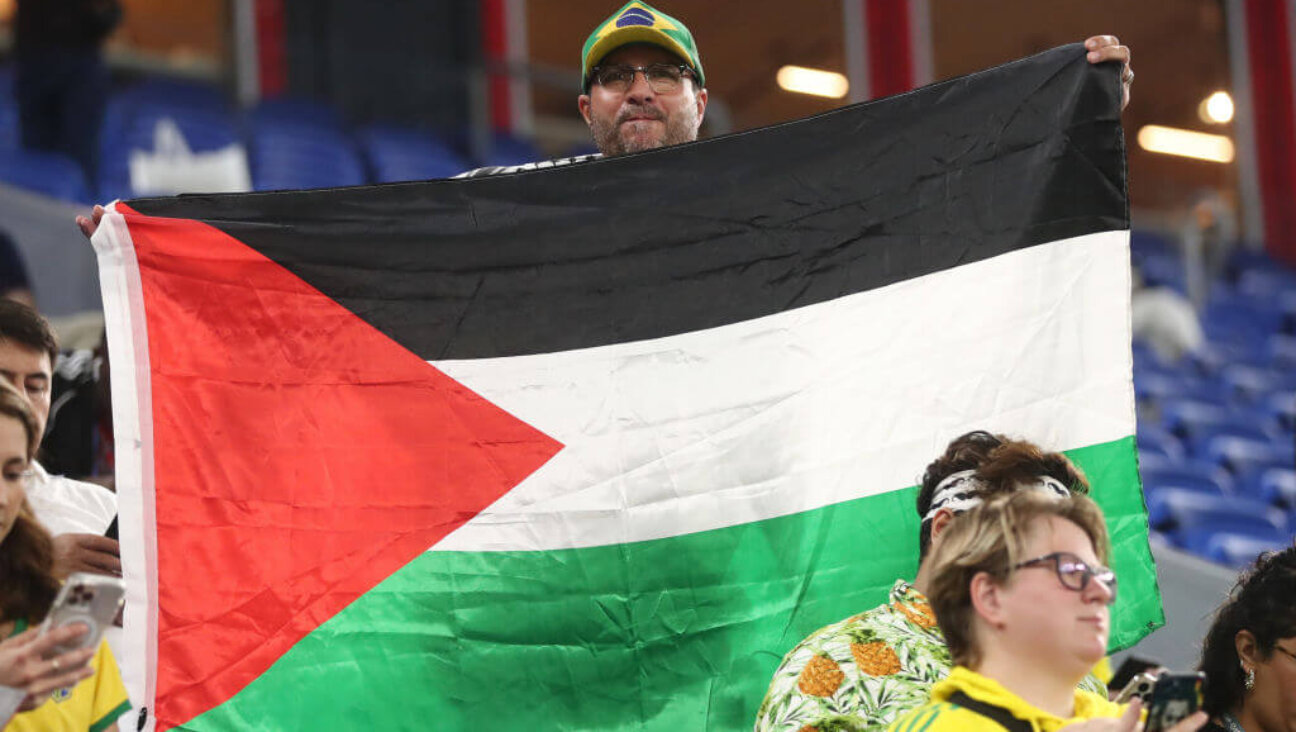 A fan of Brazil displays a Palestinian flag before the FIFA World Cup match between Brazil and South Korea on December 5, 2022 in Doha, Qatar. 