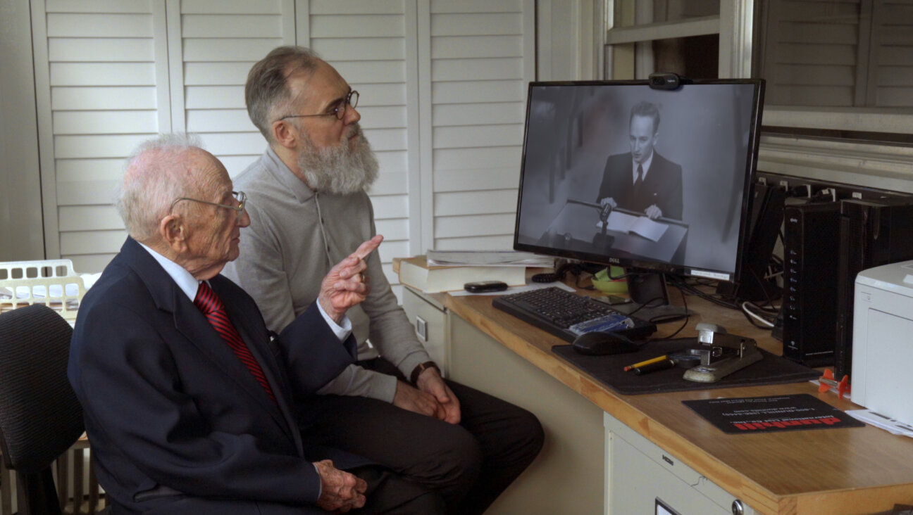Ben Ferencz and David Nocholas Wilkinson watch a younger Ferencz's statement at a Nuremberg in <i>Getting Away with Murder(s)</i>.
