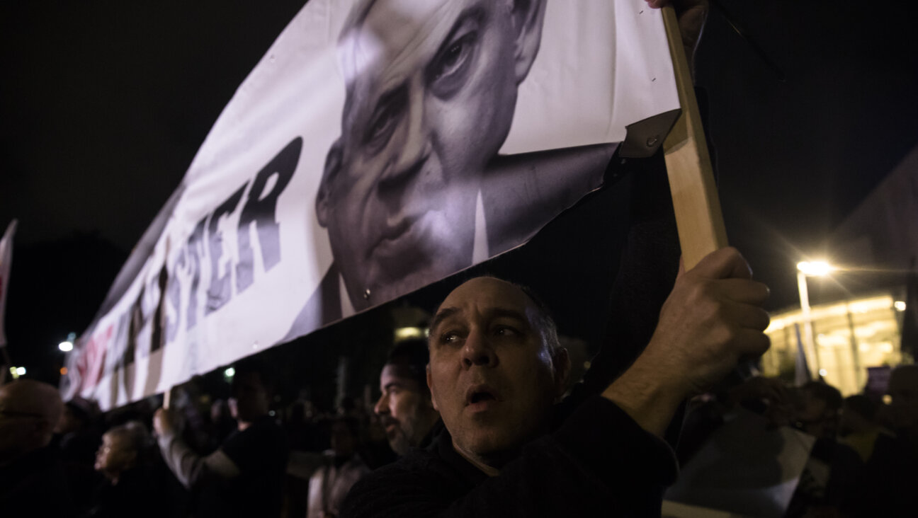  A protester holds a placard with a photo of Israeli Prime Minister Benjamin Netanyahu as he protests against the Israeli government's plan for a dramatic justice reform on January 8, 2023 in Tel Aviv, Israel