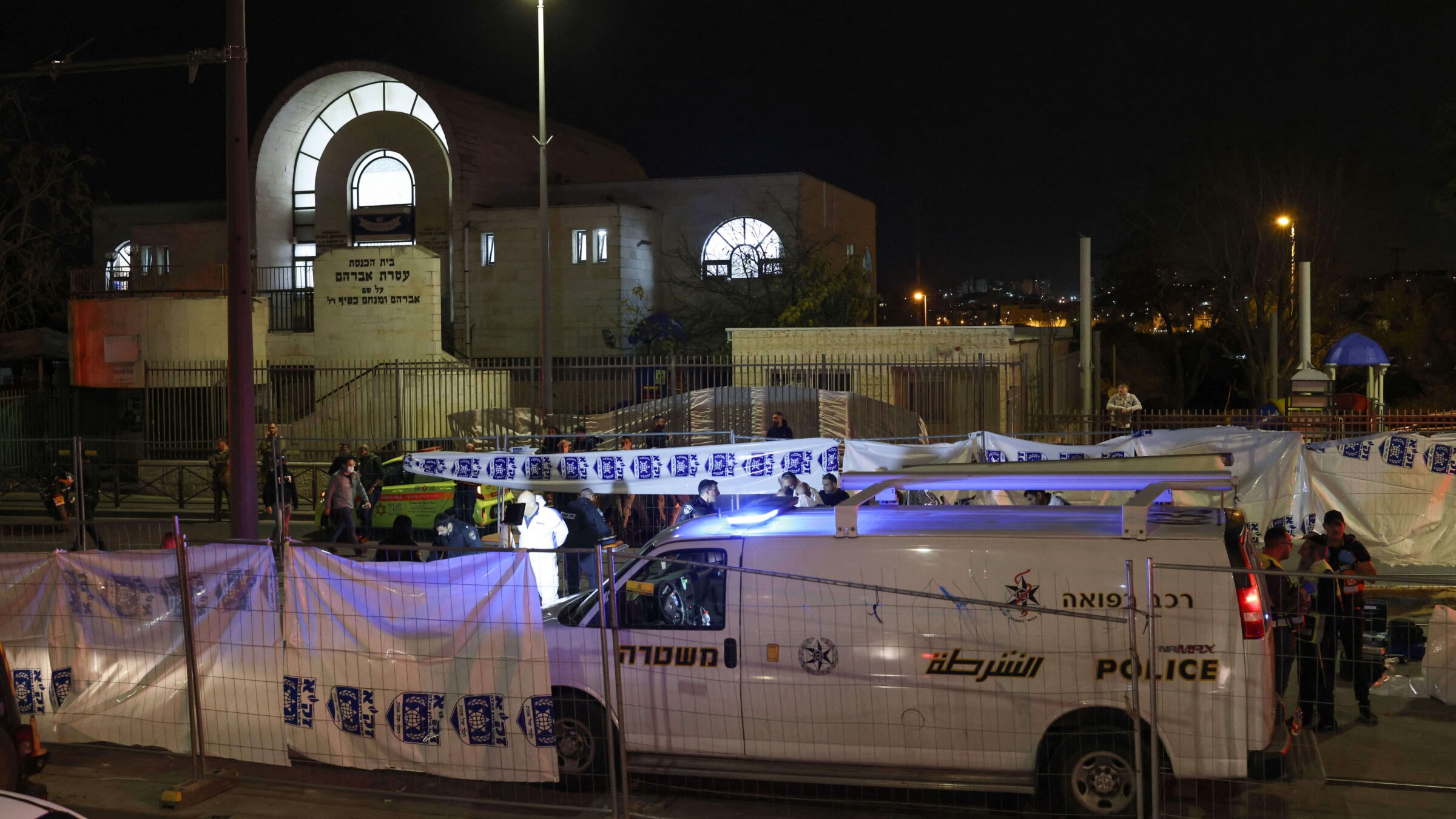 Israeli emergency service personnel close off the site of a reported attack at a synagogue in East Jerusalem.