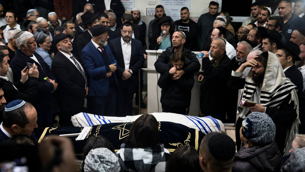 Family and friends of Eli and Natali Mizrahi, who were killed in the Friday shooting outside a synagogue in Neve Yaakov, mourn during their funeral.