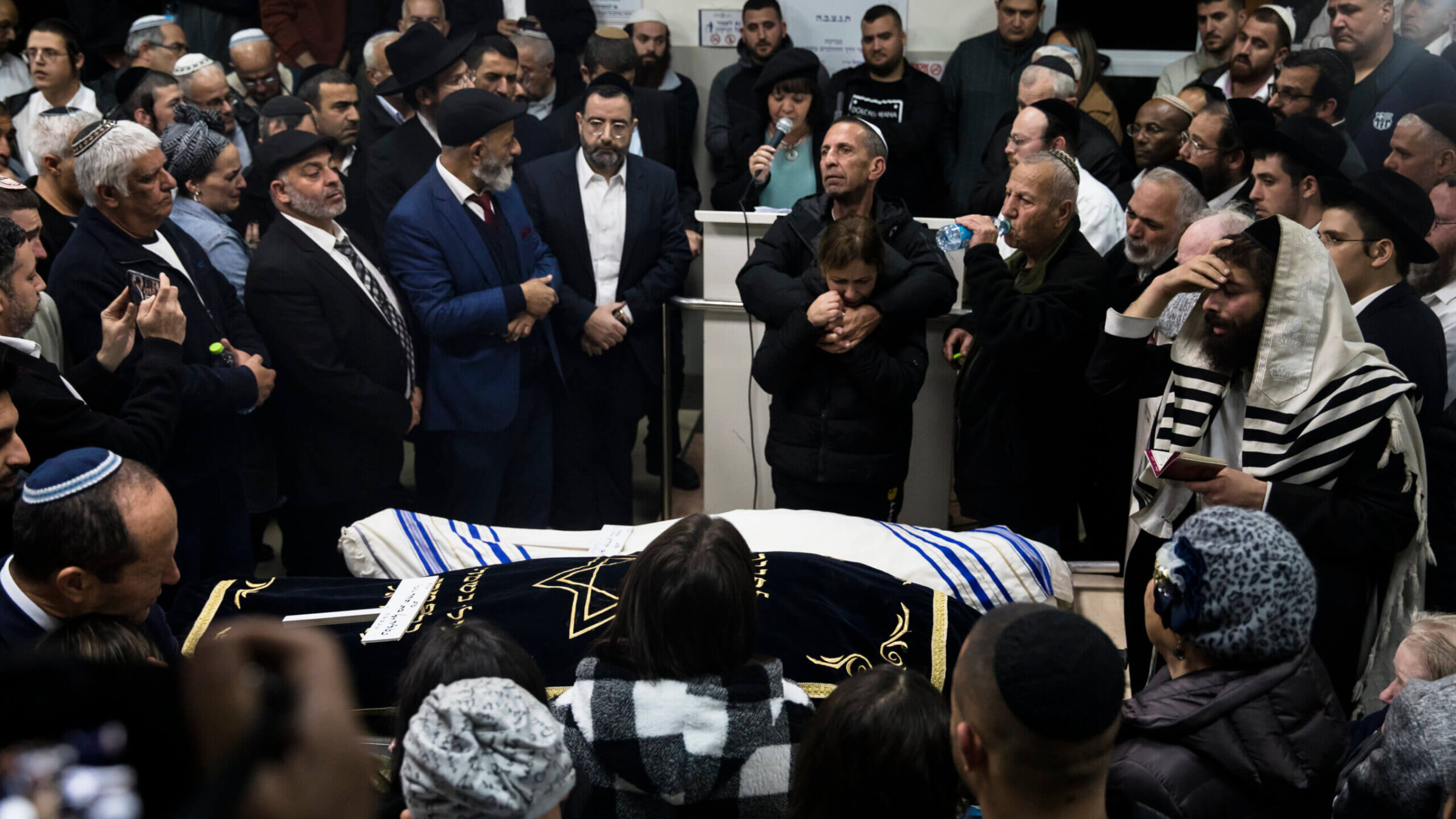 Family and friends of Eli and Natali Mizrahi, who were killed in the Friday shooting outside a synagogue in Neve Yaakov, mourn during their funeral.