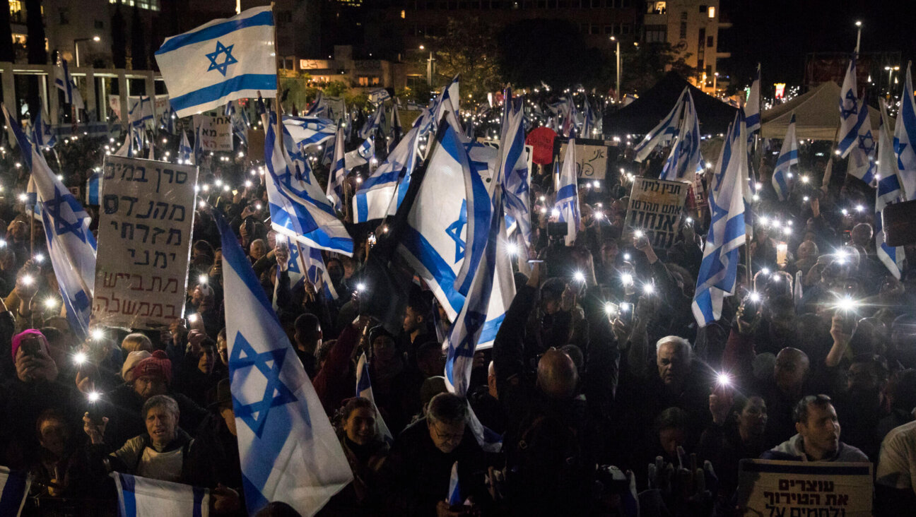 Israelis hold the Israeli flag and light their phones as they protest against the new Israeli far-right government on Jan. 14 in Tel Aviv.