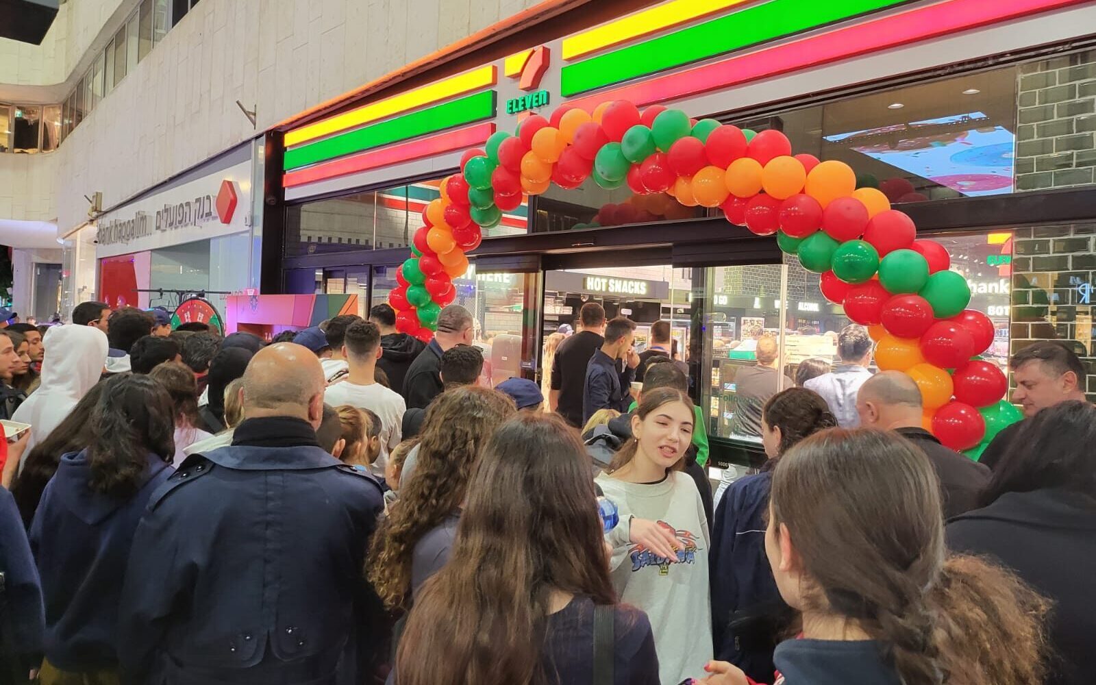 Israelis crowd outside the country’s first 7-Eleven convenience store on Tel Aviv’s Dizengoff Street, Jan. 11, 2023. (Deborah Danan)