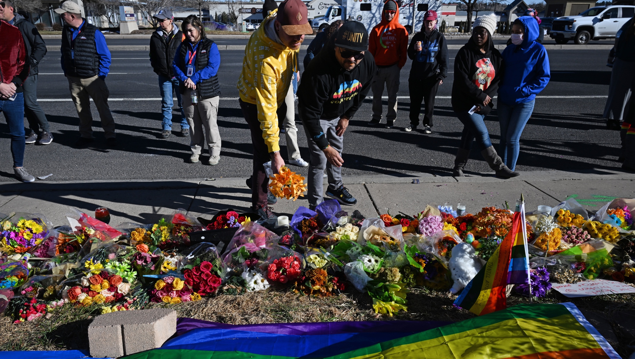 Mourners place flowers on the growing memorial where hundreds of flowers, balloons, signs and remembrances have been left for the victims of the Club Q shooting in Colorado Springs, Nov. 21, 2022. (Helen H. Richardson/MediaNews Group/The Denver Post via Getty Images)