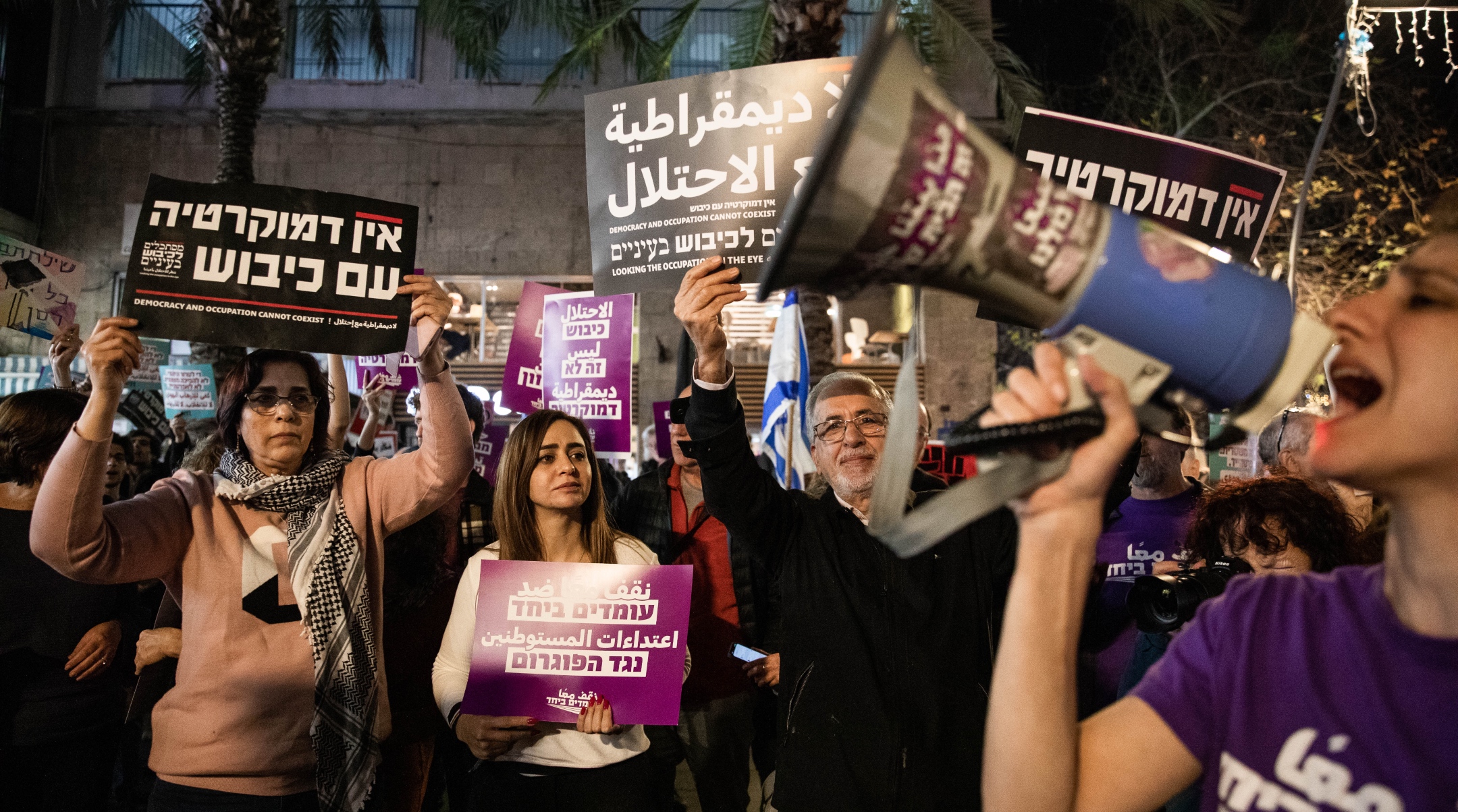 Left-wing activists in Haifa protest against the February events in Hawara. Their signs read, "No democracy with occupation."