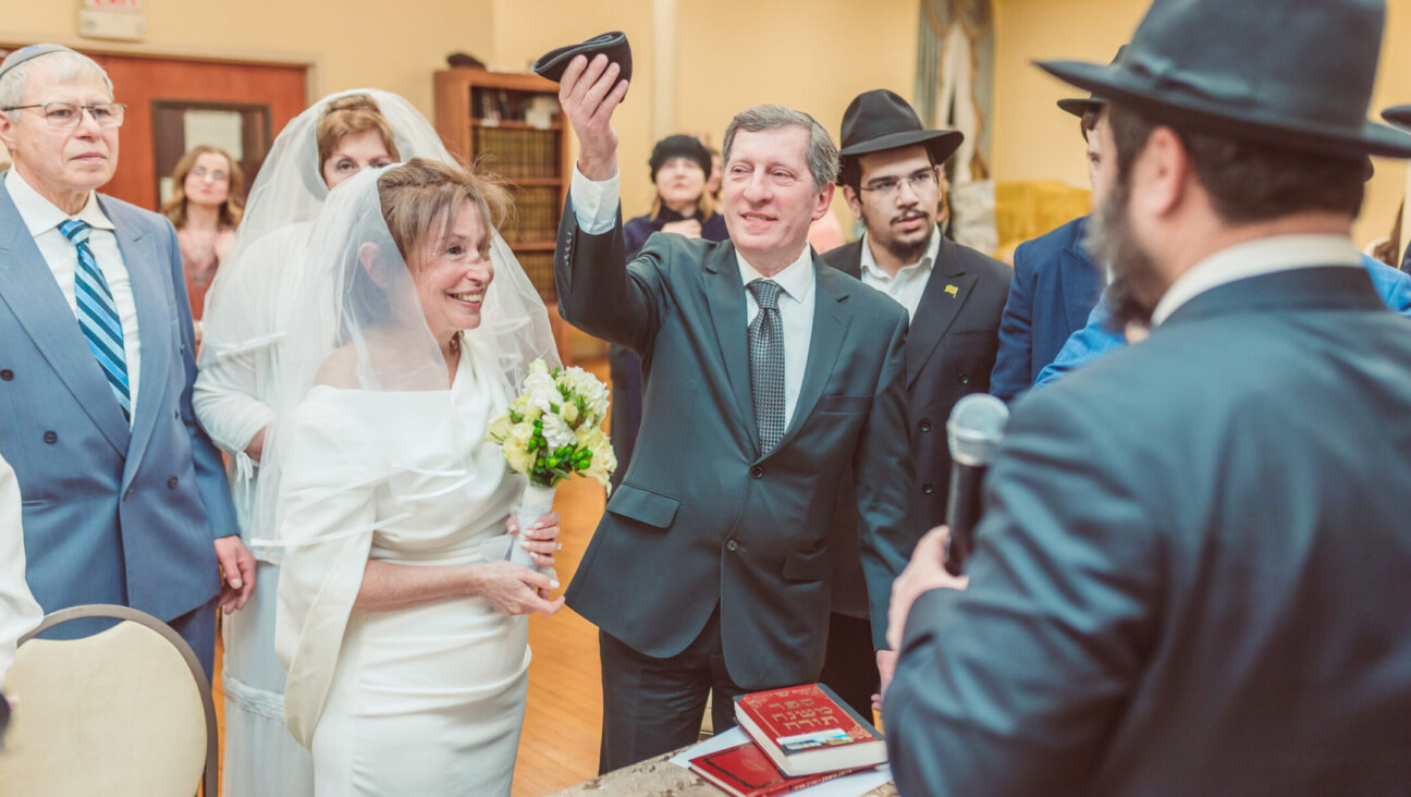 Alex Linkov raises a kippah, in a symbol of a Jewish wedding contract, next to his wife Rimma. The pair had a Jewish wedding in Boston after being married decades earlier in Ukraine. (Photo by Igor Klimov)