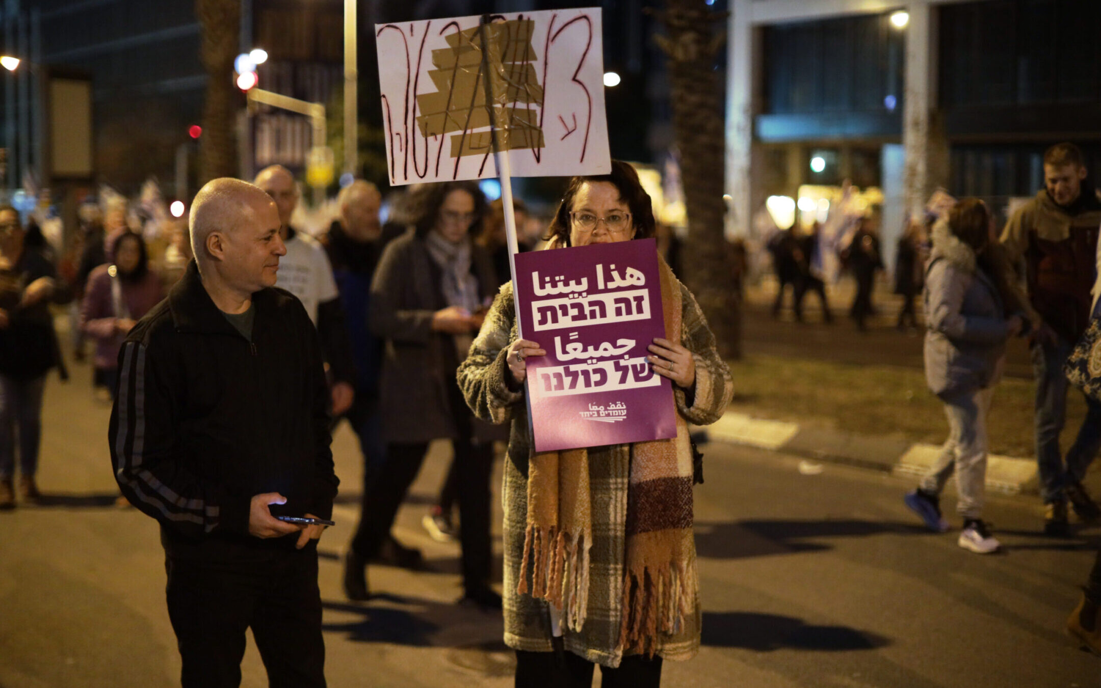 A lone protester advocating in Hebrew and Arabic for coexistence participates in a protest against planned changes to Israel’s judicial system, Tel Aviv, Feb. 11, 2023. (Saeed Qaq/Anadolu Agency via Getty Images)
