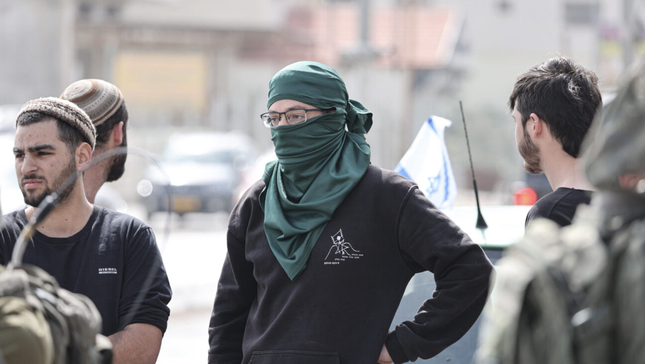 Israeli settlers stand at the side of a road in the Palestinian town of Huwara following a violent night in which houses and vehicles were set on fire, Feb. 27, 2023. (Photo by Ilia Yefimovich/picture alliance via Getty Images)
