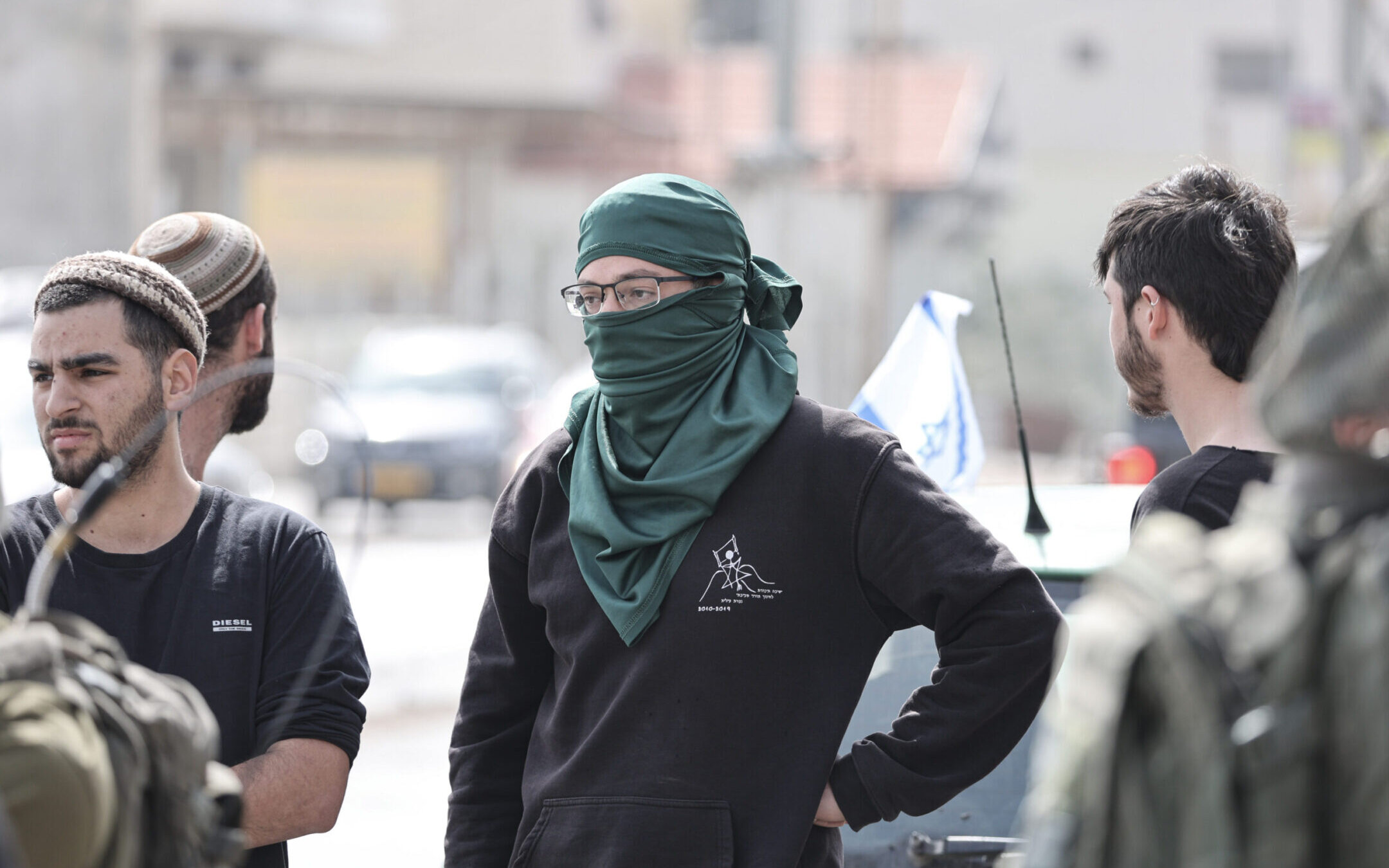 Israeli settlers stand at the side of a road in the Palestinian town of Huwara following a violent night in which houses and vehicles were set on fire, Feb. 27, 2023. (Photo by Ilia Yefimovich/picture alliance via Getty Images)