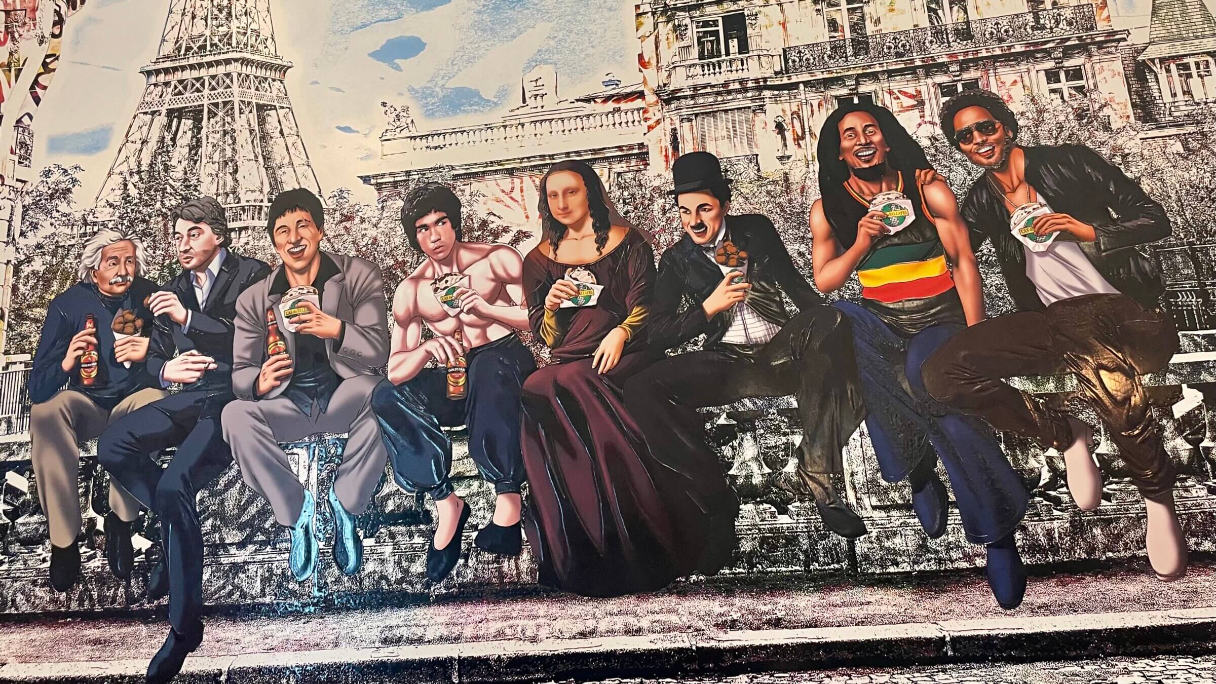 Lenny Kravitz, Bob Marley, Albert Einstein, Charlie Chaplin, and the Mona Lisa are among those enjoying falafel on the Rue des Rosiers.