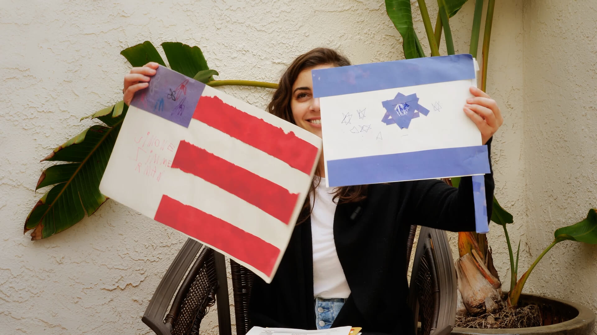 A still from the film showing Simone Zimmerman holding up childhood drawings.