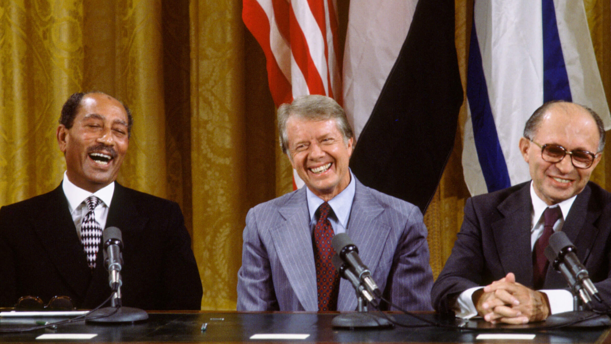 (L to R) Egyptian President Anwar al-Sadat, US President Jimmy Carter, and Israeli Premier Menachem Begin laugh together during the signing the Camp David Accords in the East Room of the White House, September 18, 1978, in Washington, DC. The agreement came after twelve days of secret negotiations at Camp David.