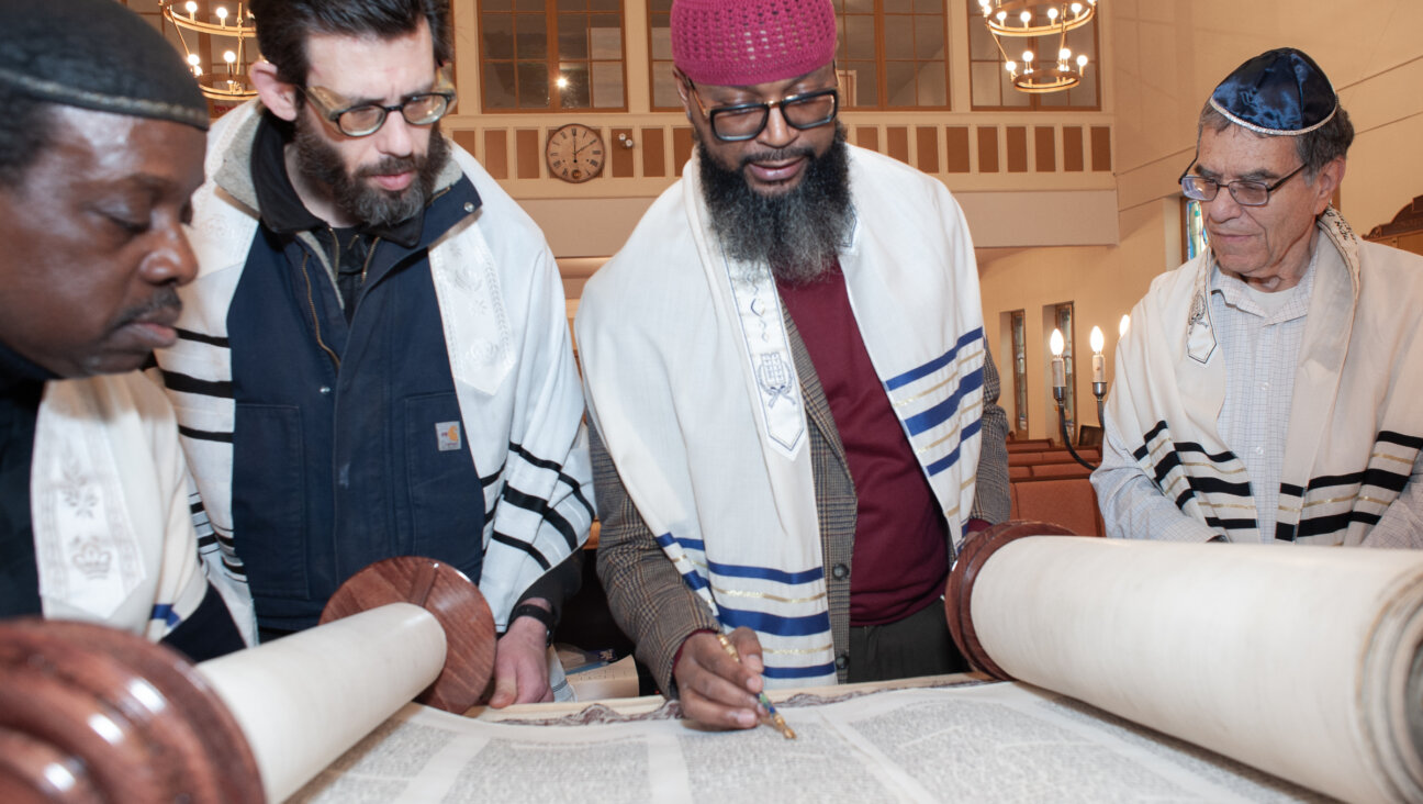 <i>From left:</i> Robert Azriel Devine, Tucker Sabath, Eliyahu Elijah Collins and Matthew Boxer inspect a Torah scroll in preparation for a future service at Newark's Congregation Ahavas Sholom. The Conservative synagogue has added Devine and Collins, who are students at New York's Israelite Rabbinical Academy, to its spiritual staff. 