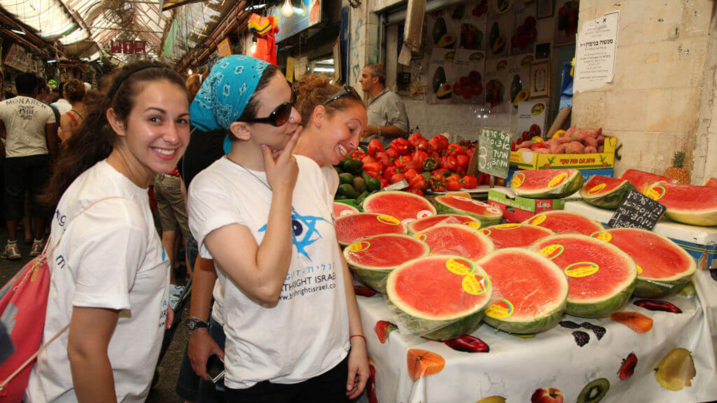 Three young American tourists on the Birthright (Taglit) program checking out the watermelon on a fruit stand in the Machane Yehuda Market, Jerusalem, Israel, August 28, 2009. 