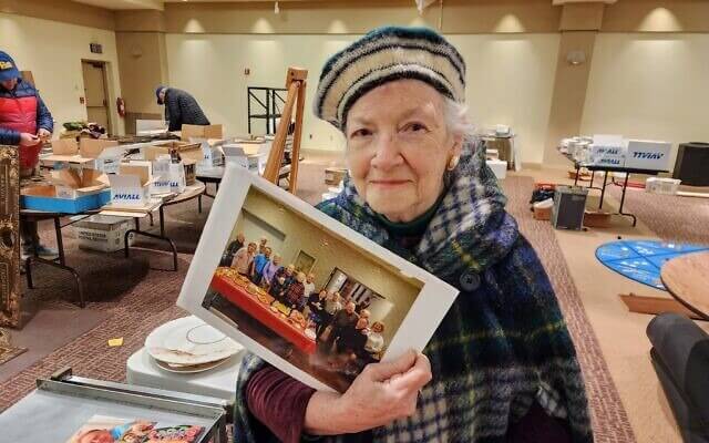 Linda Schugar holds a photo of her and other Tree of Life minyan-goers.