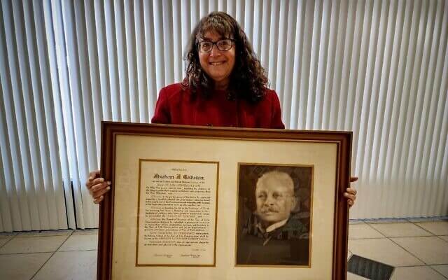 Diane Heller Klein holds a photo and proclamation heralding her great-grandfather for his half-century of service to Tree of Life.