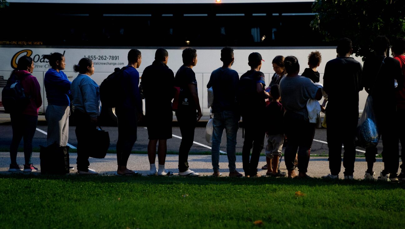 Migrants who boarded a bus in Texas listen to volunteers offering assistance after being dropped off within view of the U.S. Capitol building in Washington, D.C., on Aug. 11, 2022.