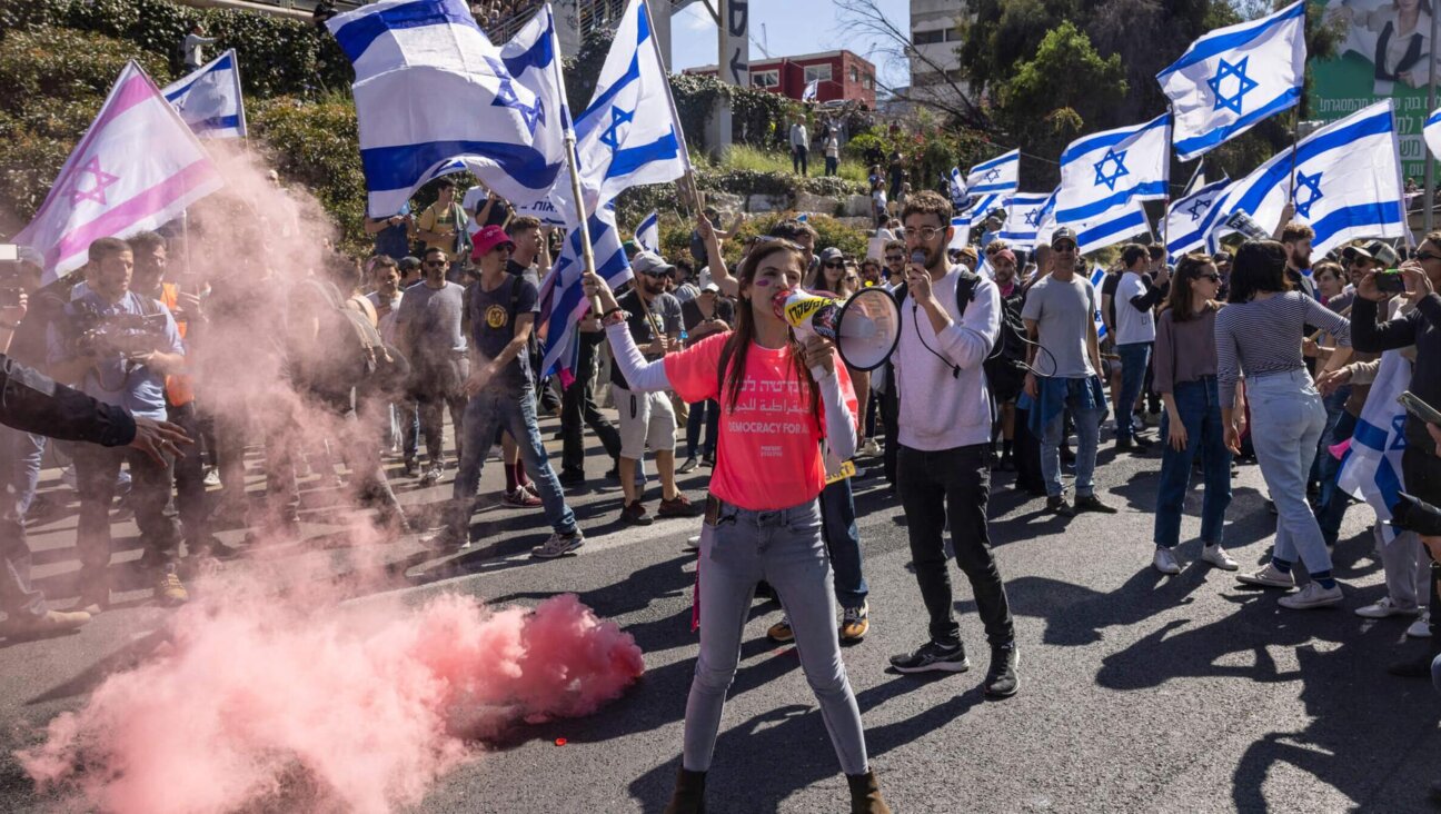 Tech workers wave flags and set off smoke bombs during a protest in Tel Aviv. 
