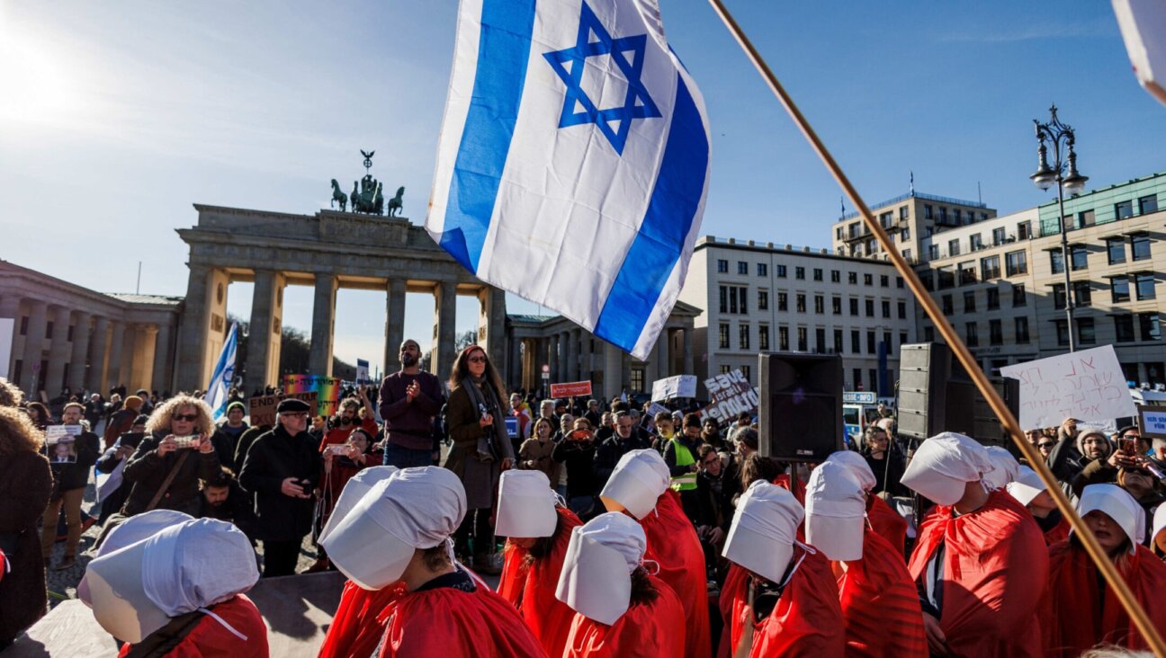 Demonstrators dressed in red costumes inspired by “The Handmaid’s Tale” protest against the Israeli government in front of the Brandenburg Gate on the occasion of the Israeli prime minister’s visit to Berlin. (Carsten Koall/picture alliance via Getty Images)