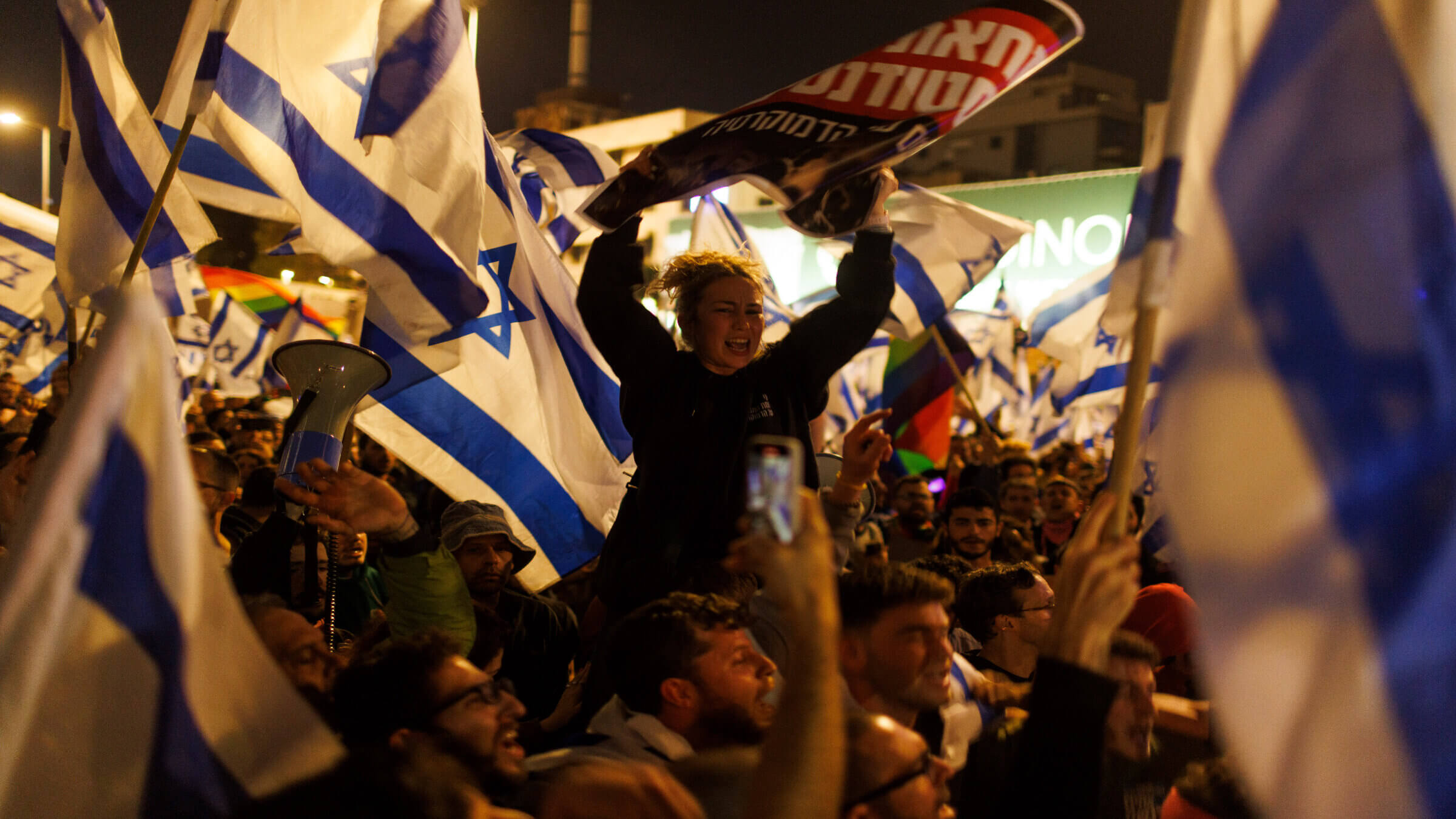 Demonstrators wave Israeli national flags as they block the Ayalon Highway during a protest against prime minister Benjamin Netanyahu's coalition government and proposed judicial reforms in Tel Aviv, Israel, on Sunday, March 26, 2023.