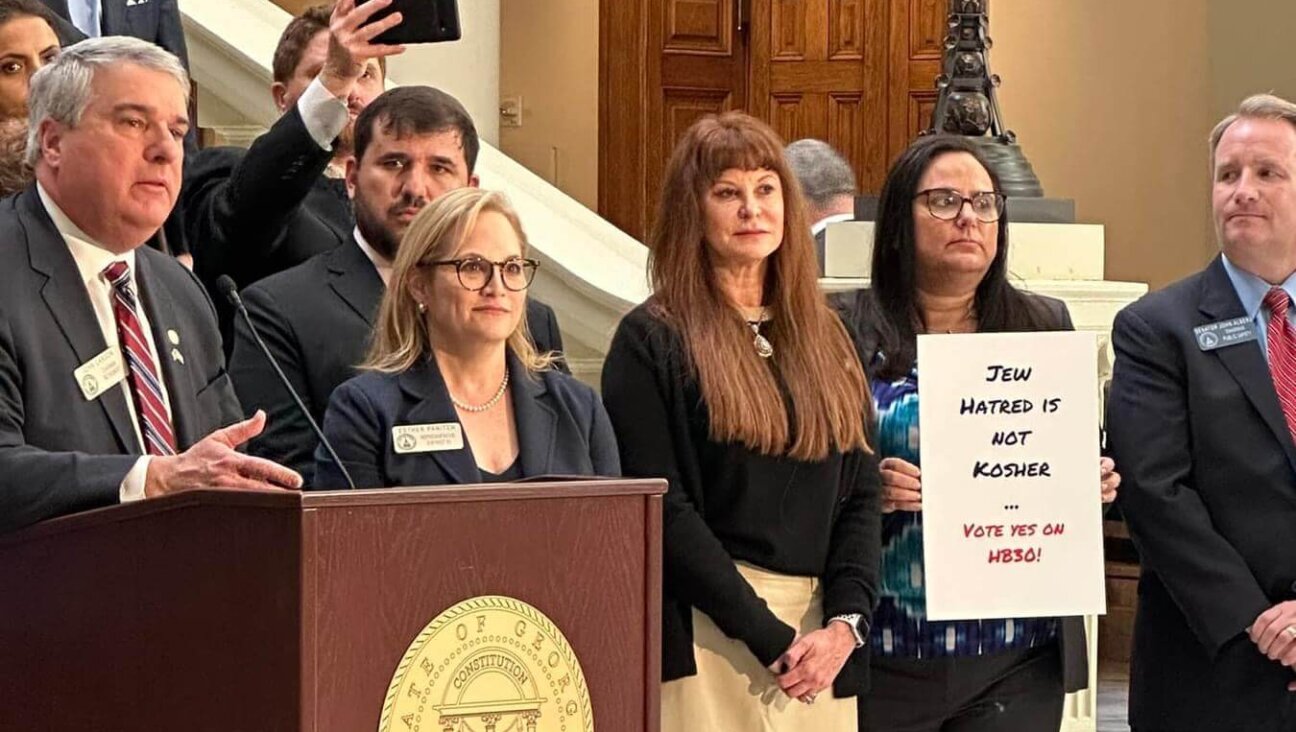 Georgia state representatives John Carson and Esther Panitch stand with members of Jewish organizations. The two co-sponsored a bill to combat antisemitism. 