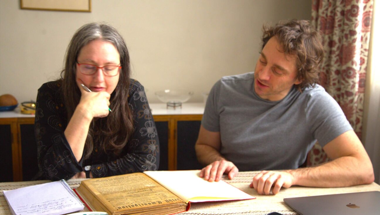 Naomi Seidman and Kalman Weiser looking through some rare town records at the home of David Birnbaum, in Toronto