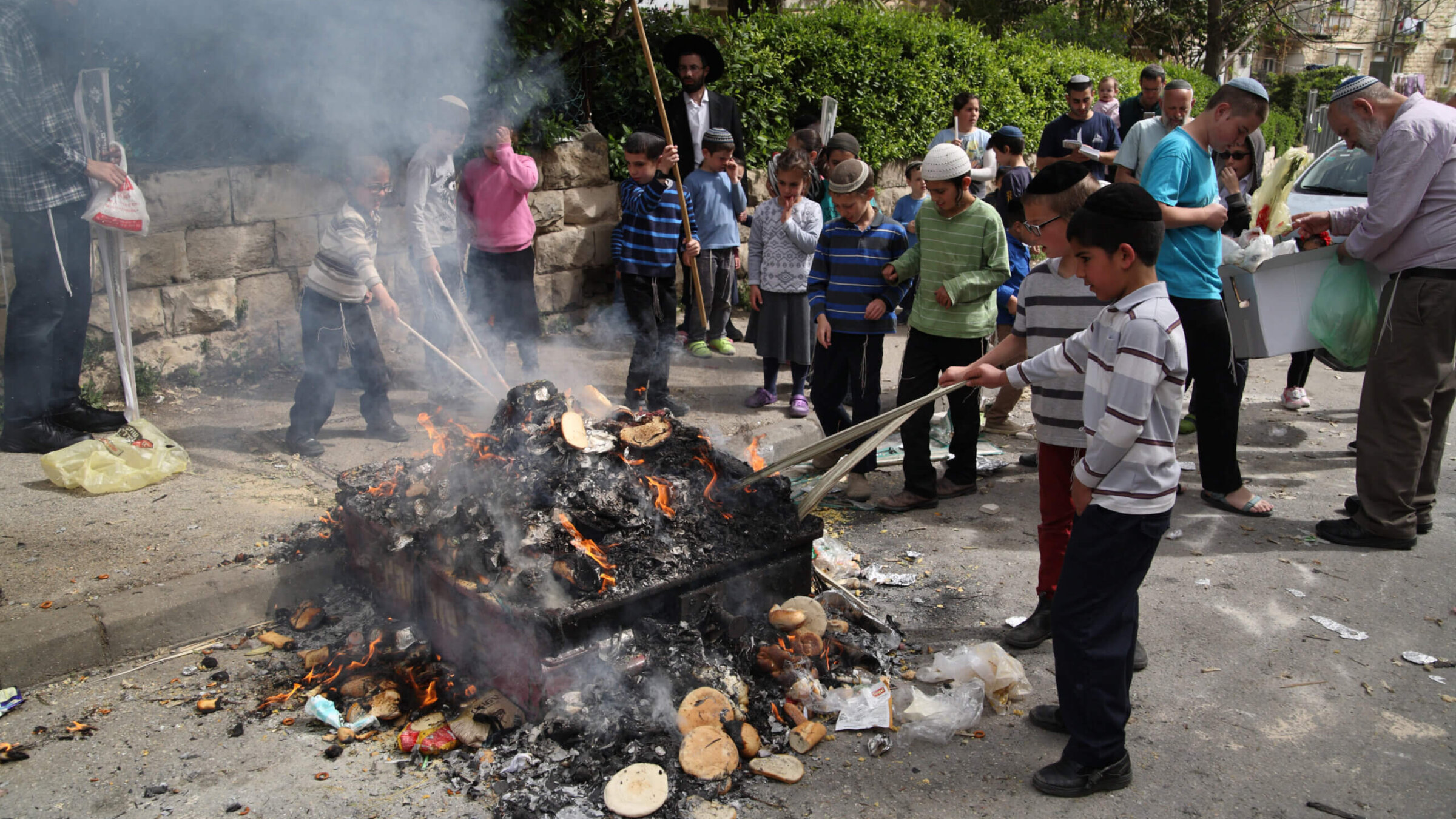 In the Kiryat Moshe neighborhood in Jerusalem, children poke at embers in the Orthodox Jewish practice of burning chametz (leaven, or not Kosher foods) on the morning of Passover eve, Jerusalem, Israel, April 10, 2017. 